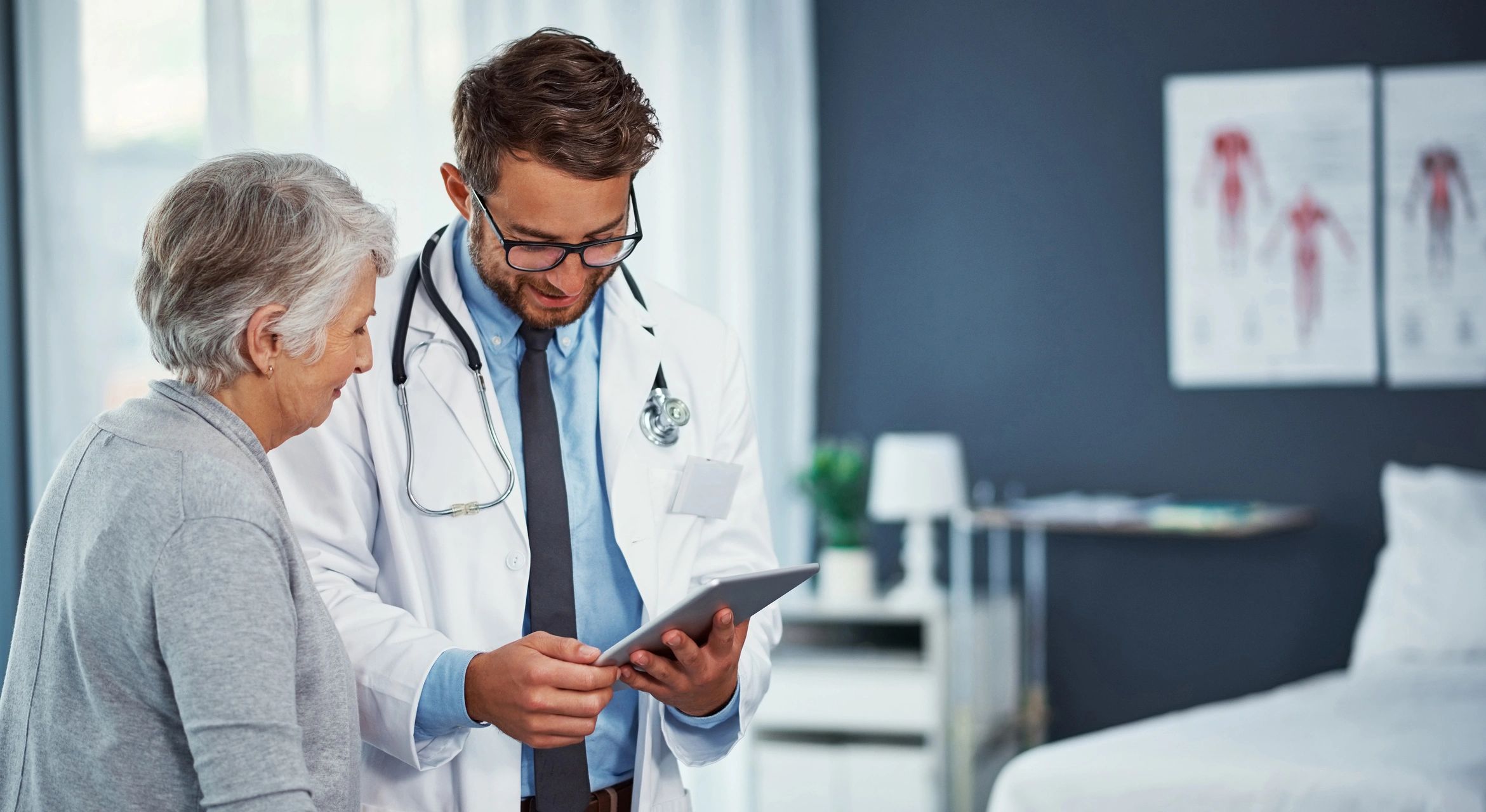 Doctor showing medical information on a tablet to an elderly woman.
